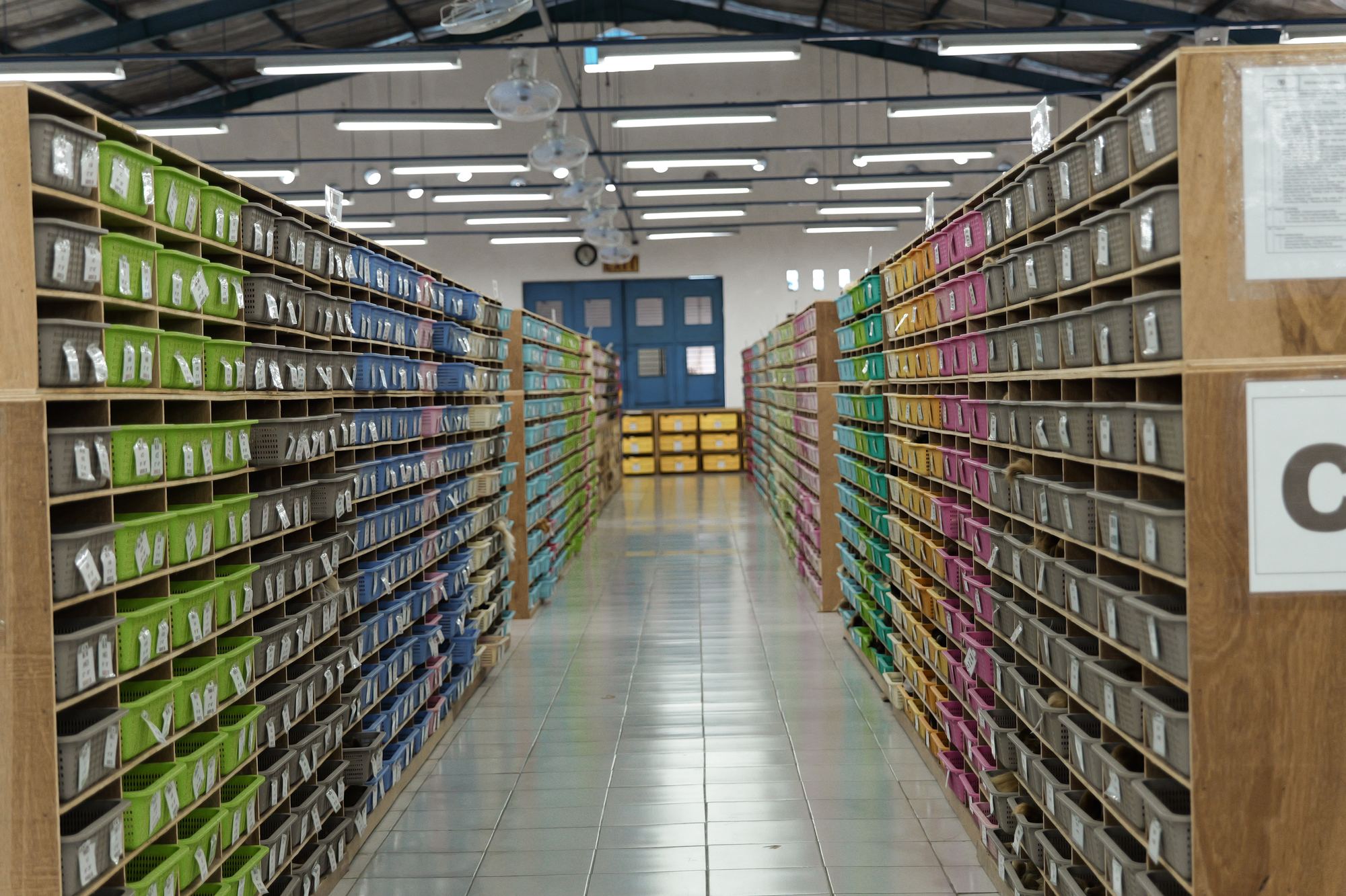 Aisle of labeled component bins in material storage
