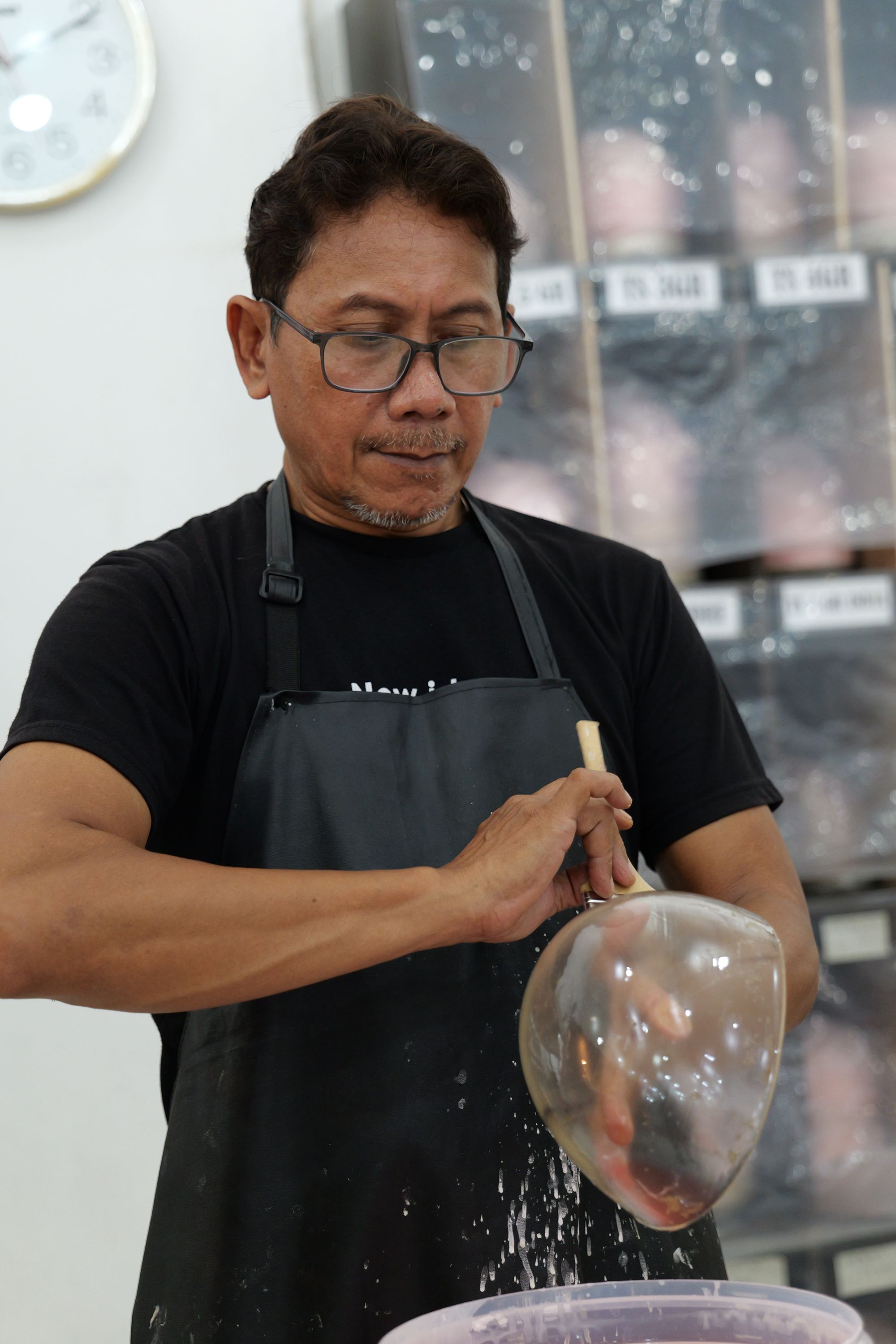 Technician steam-setting a wig on a block