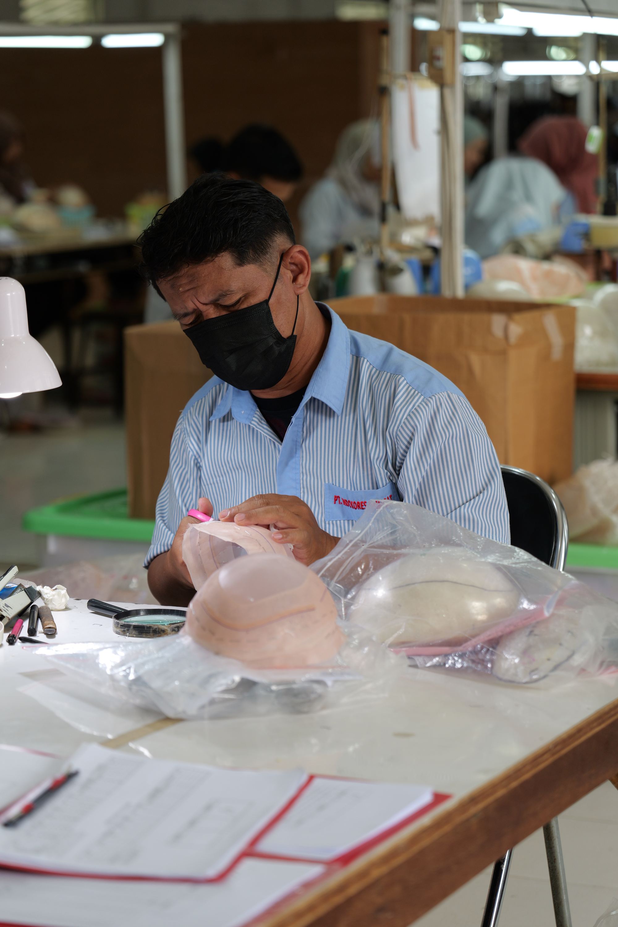 Technician marking a base pattern for a men's toupee