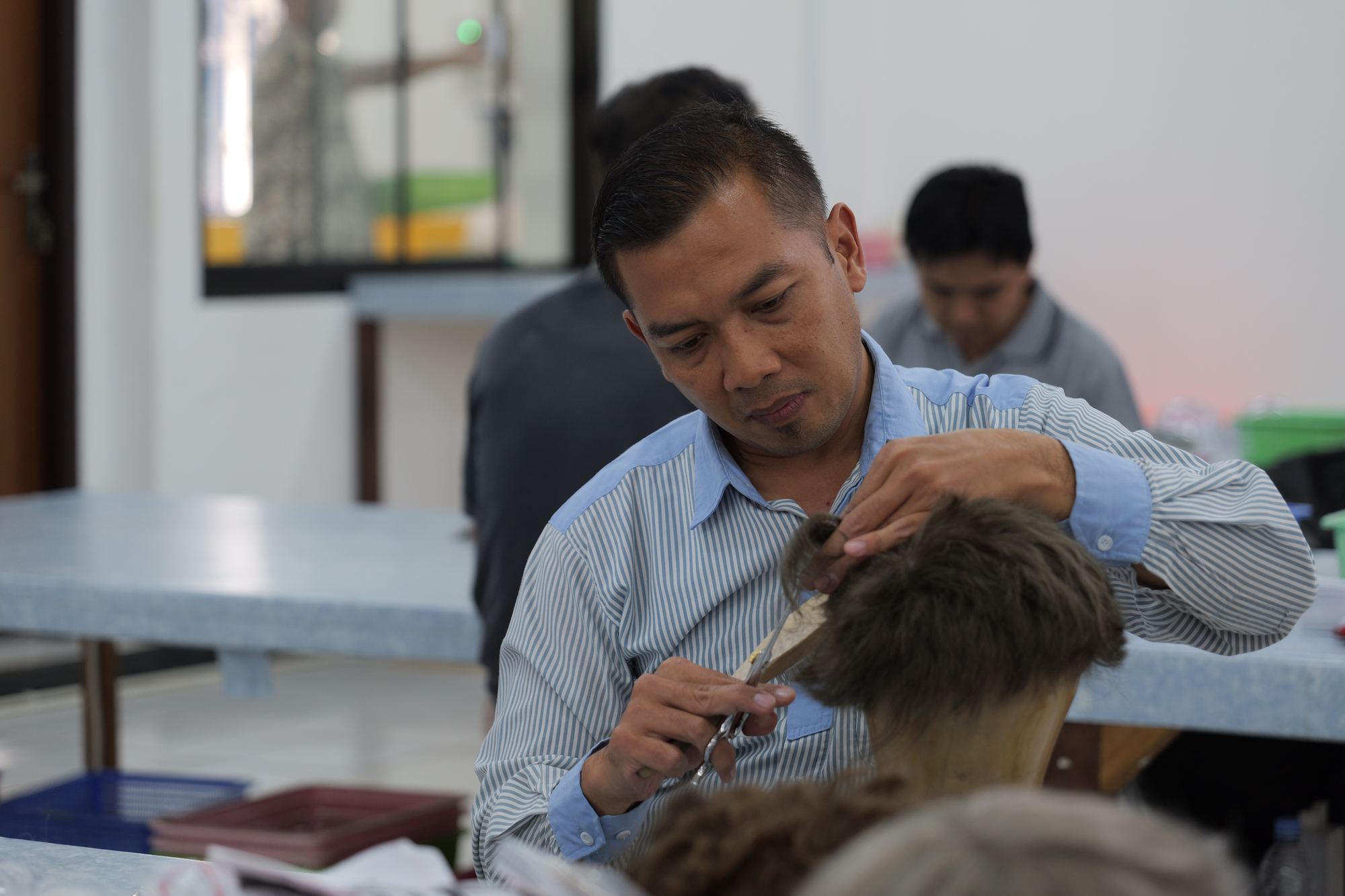 Technician finishing and cutting a wig on a mannequin block